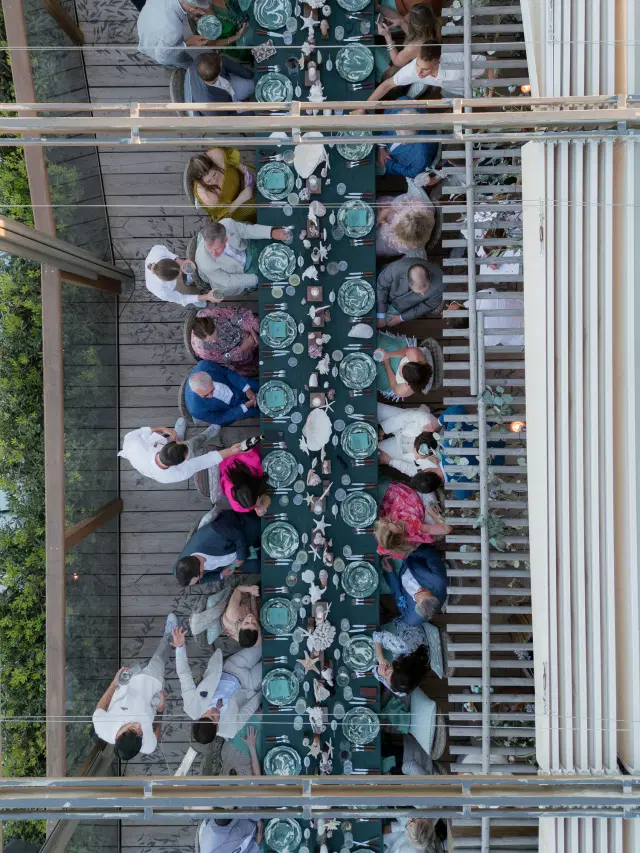 Overhead view of guests dining at a long coastal-inspired table at an Easton Events wedding in St. Tropez.