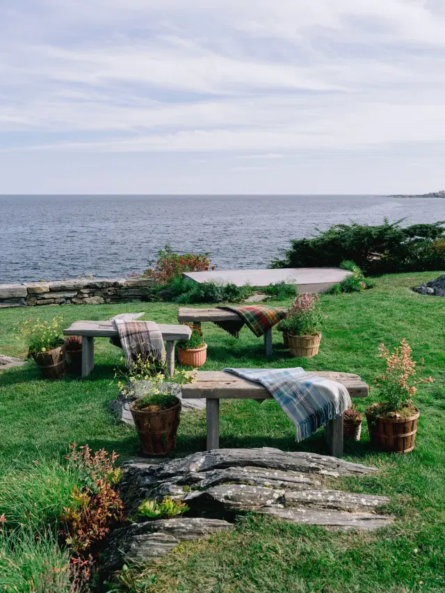 Rustic wooden benches with plaid blankets overlooking the Maine coast at an Easton Events wedding.
