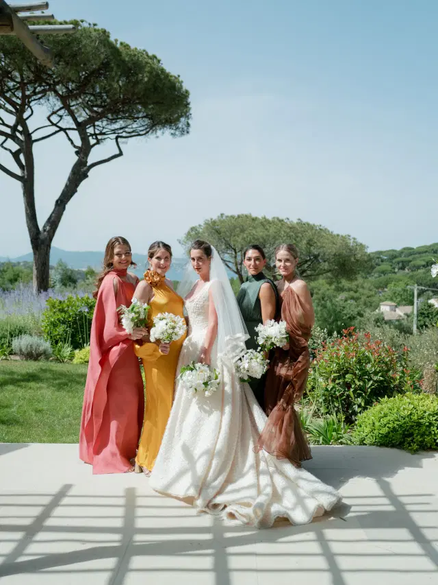 Bridesmaids in coral, golden yellow, forest green and brown gowns at an Easton Events wedding in Saint-Tropez.